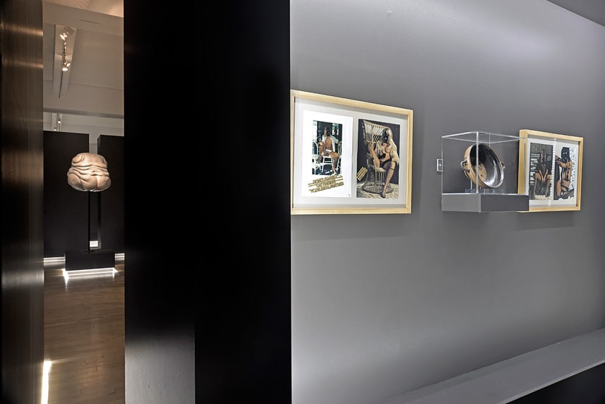 Contemporary art gallery with framed photographs and sculpture display.