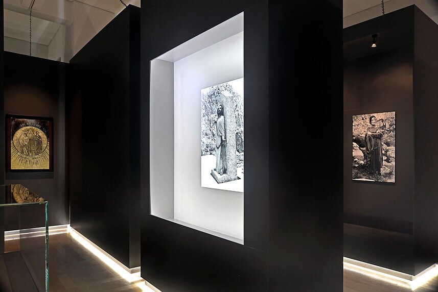 Modern art display in a sleek black gallery with spotlighted sculptures.