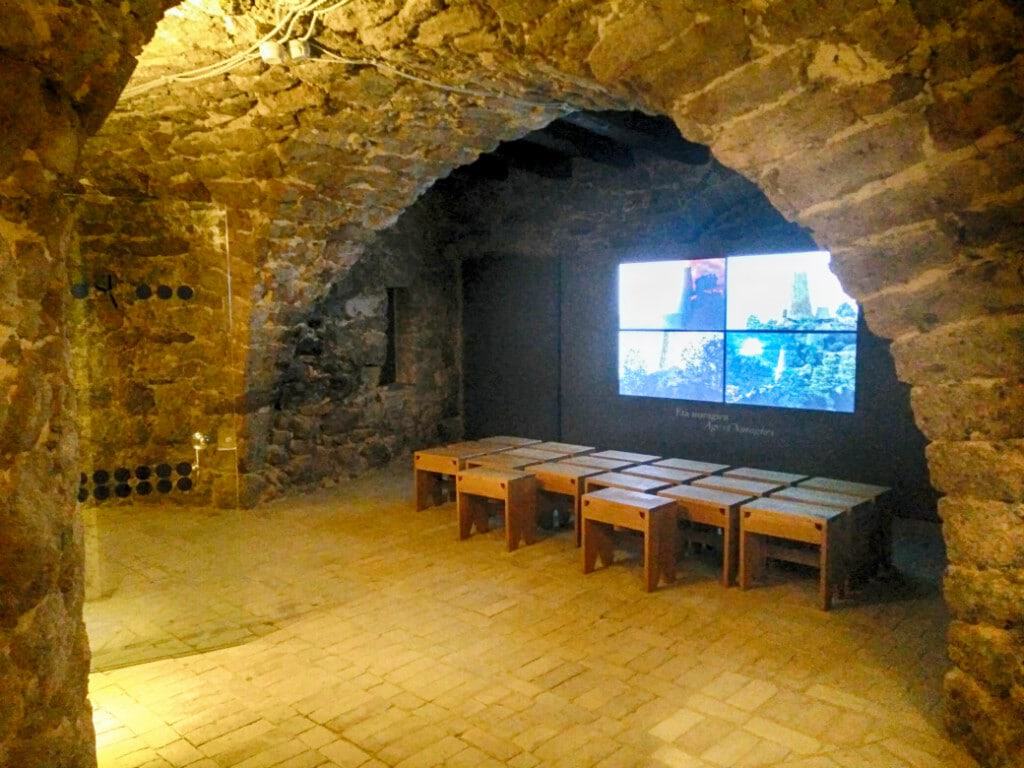 Interior view of the new museum in Carloforte with stone arches and digital display.