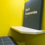 Motivational Quote 'Don'T Compromise' On A Black Canvas In A Modern Coworking Space.
