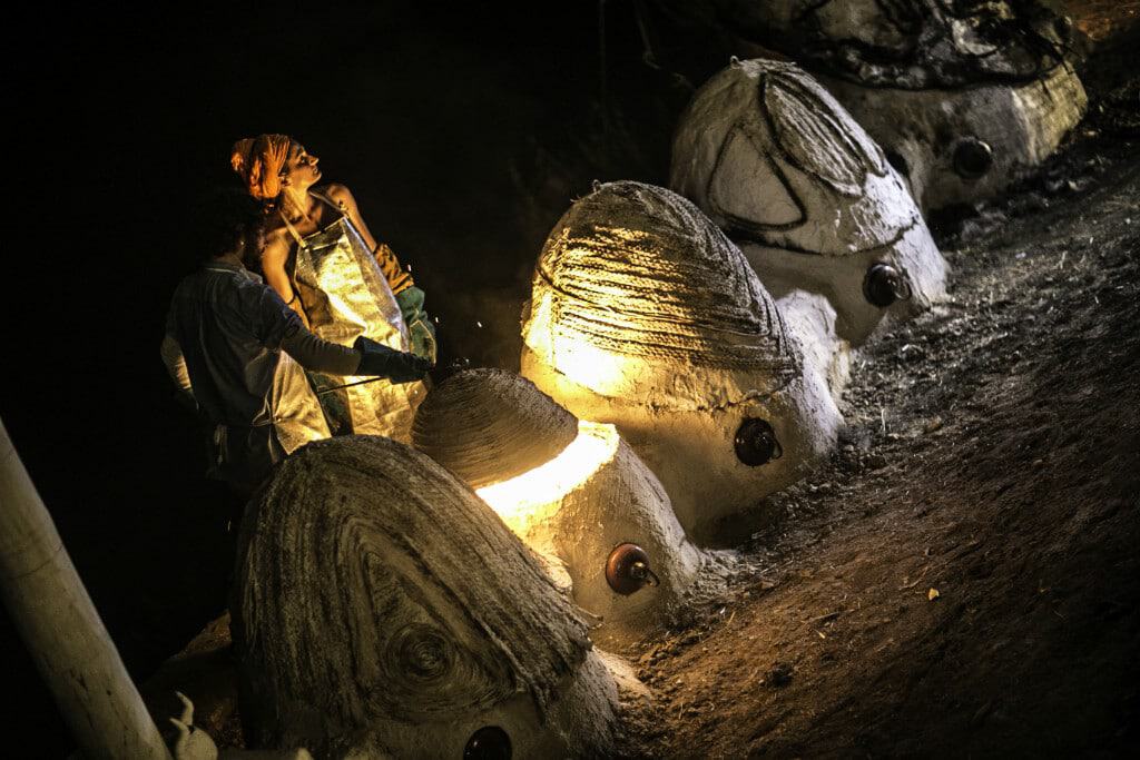 Artistic illuminated sculptures resembling animal heads at night.
