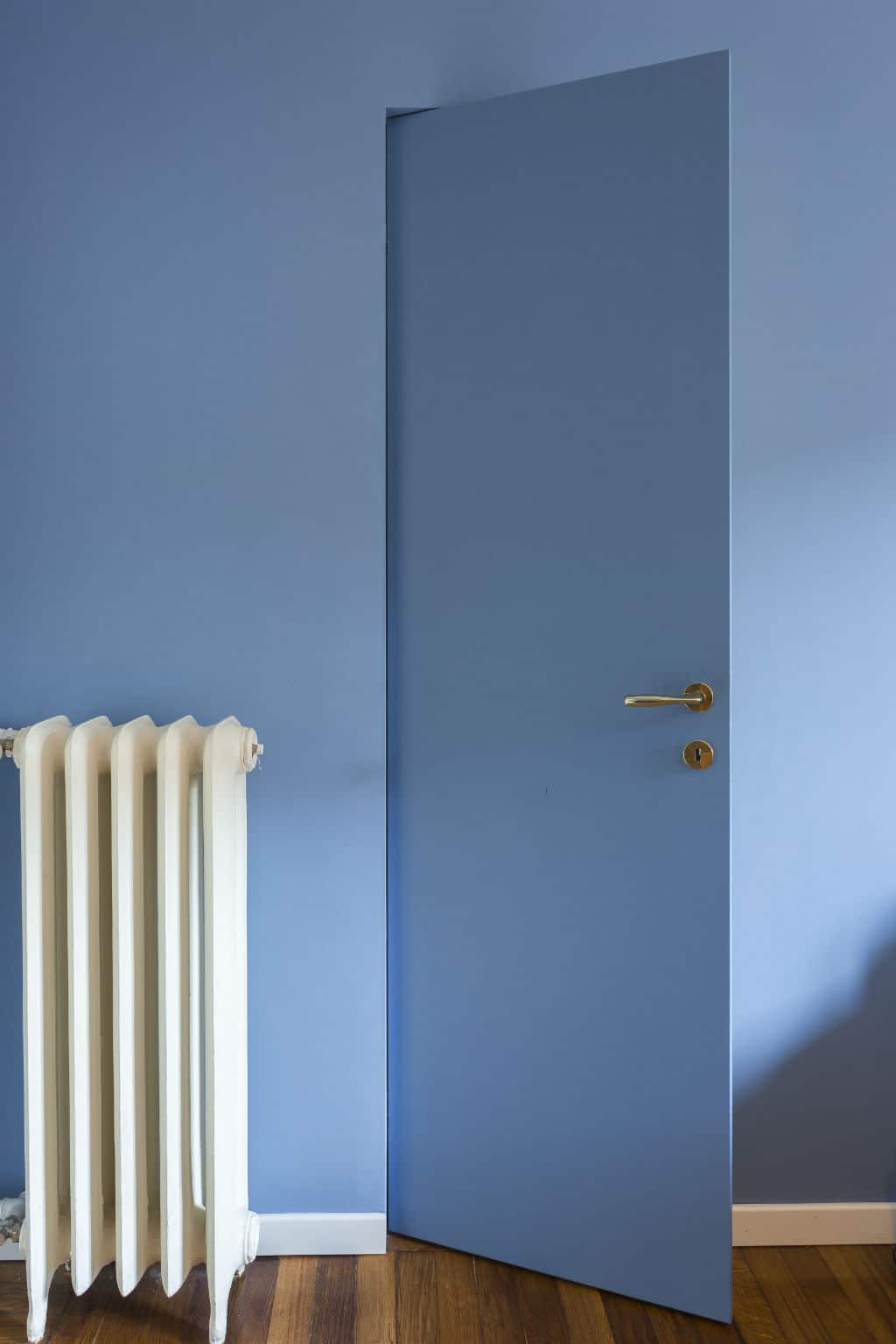 Blue interior door with gold handle in a modern room.