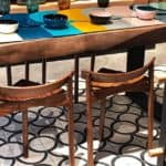 Contemporary Dining Table With Wooden Chairs And Colorful Bowls For Stylish Decor.