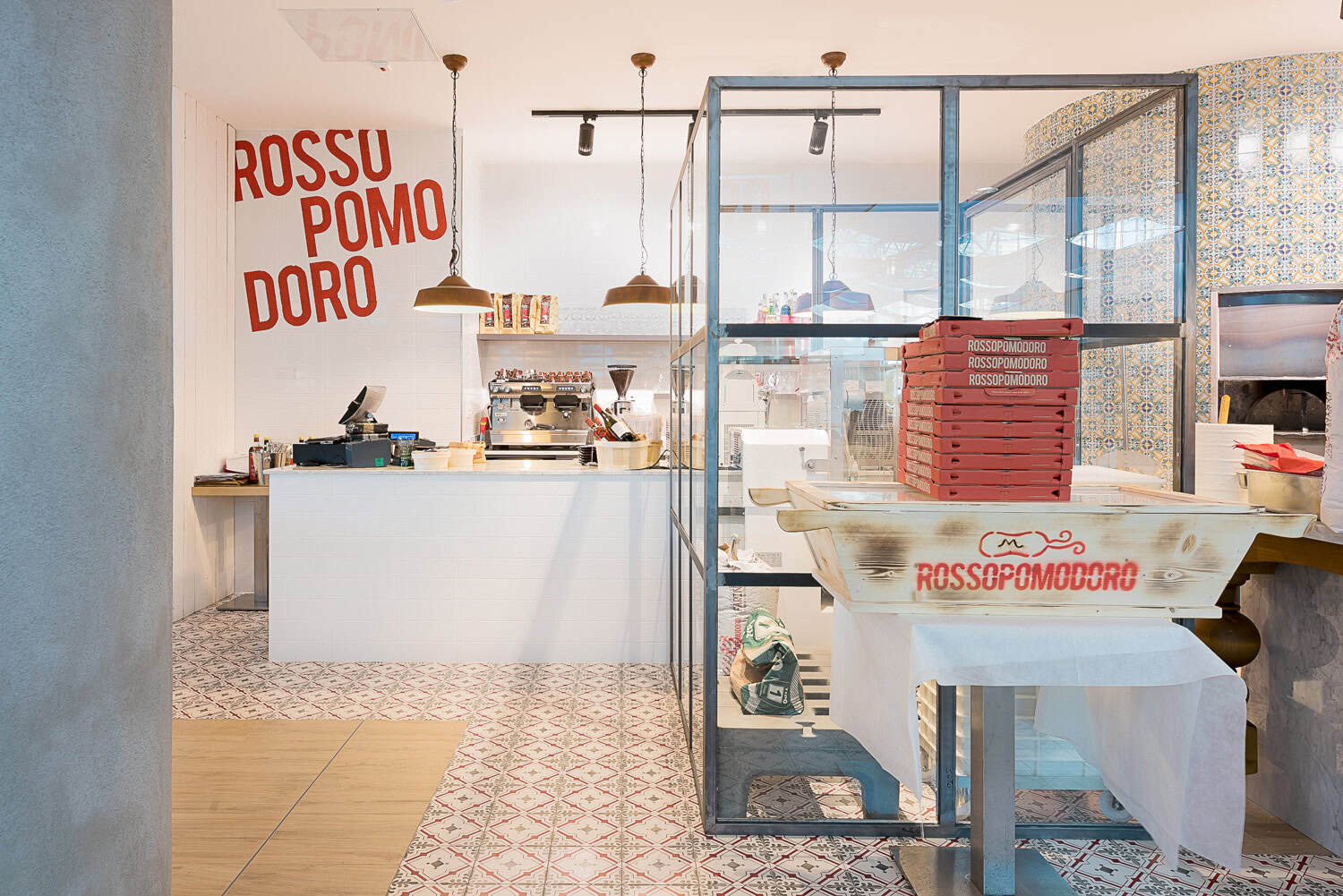 Interior view of Rossopomodoro restaurant with pizza oven and seating area.