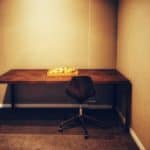 Minimalist Office Desk With A Black Chair And A Bowl Of Apples.