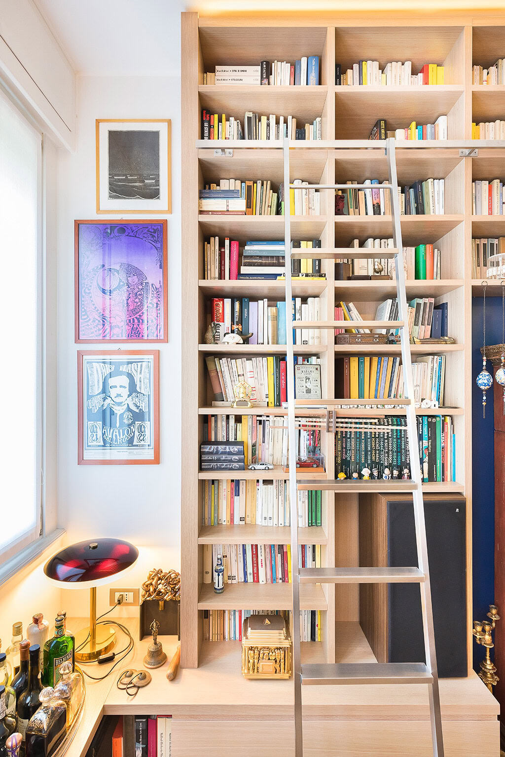 Modern wooden library with ladder and colorful books for reading and study.