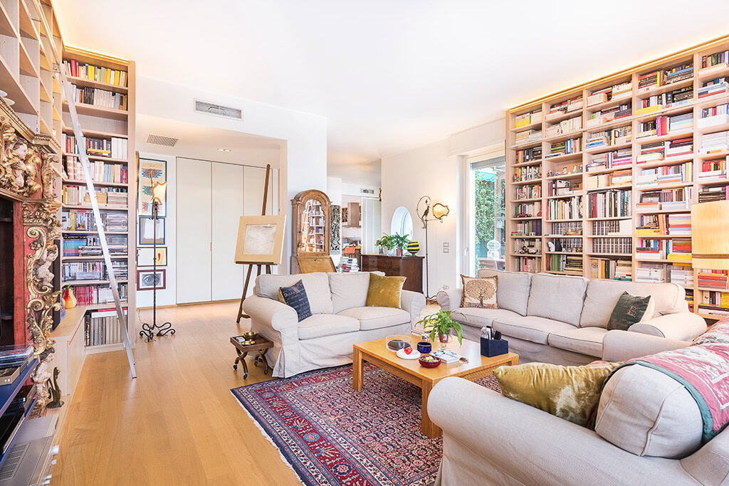 Spacious modern library with floor-to-ceiling bookshelves and cozy seating area.