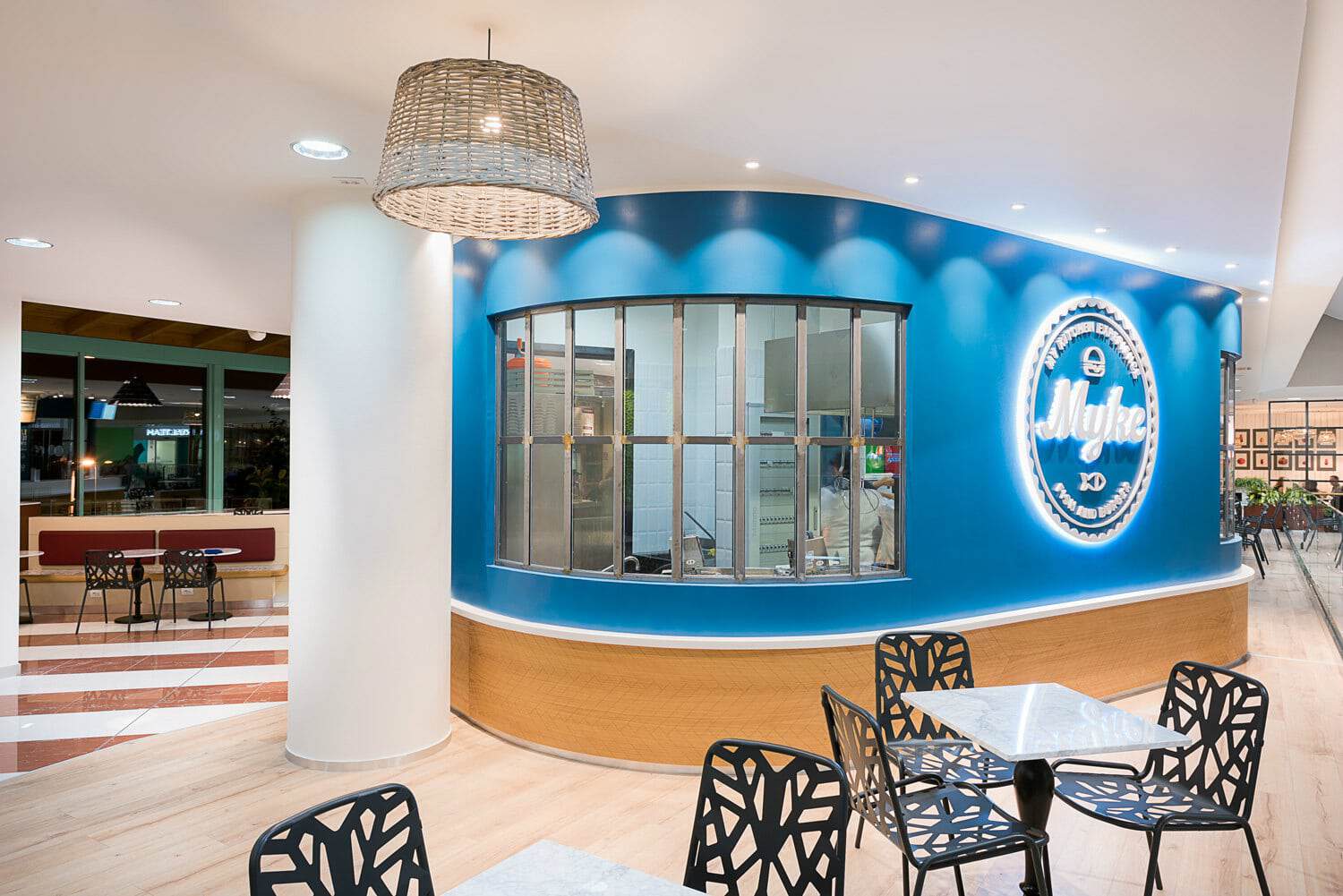 Myke Fish & Burger restaurant interior with blue wall and seating area.