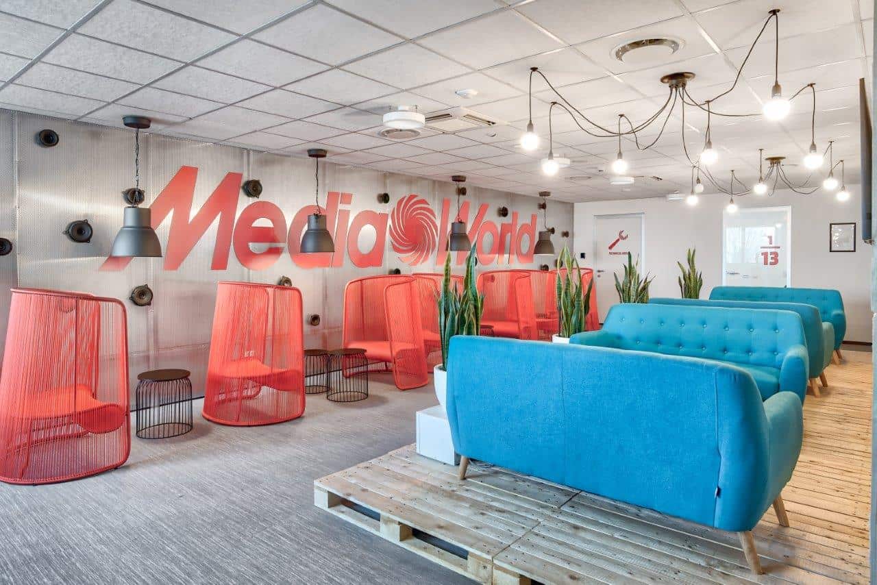 Contemporary Office Lounge With Colorful Seating And Media World Logo.