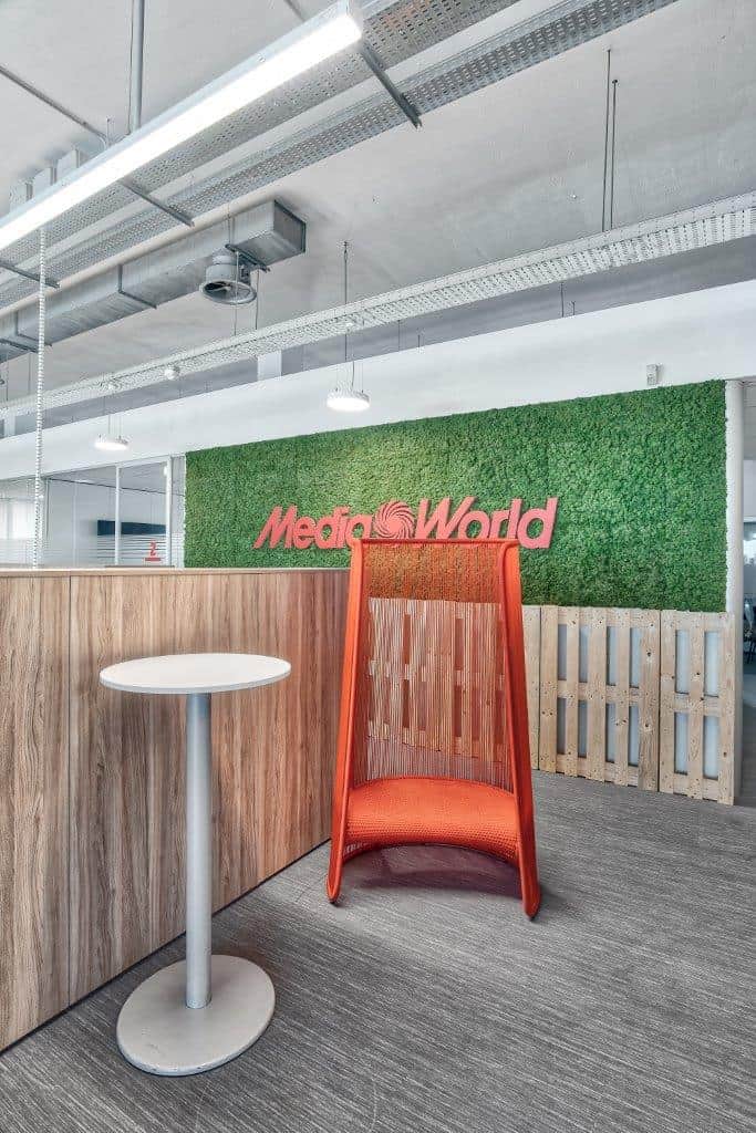 Modern office interior with green wall and orange lounge chair.