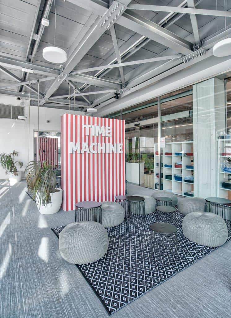 Modern office lounge with striped wall and seating area.