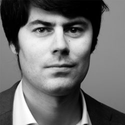 Black And White Portrait Of A Young Man With Dark Hair And Serious Expression.