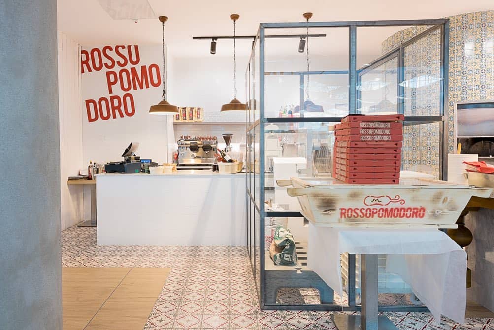 Interior View Of Rossopomodoro Restaurant With Modern Decor And Pizza Oven.