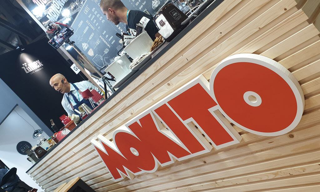 Mokito Host 2019 booth with barista and branding display.