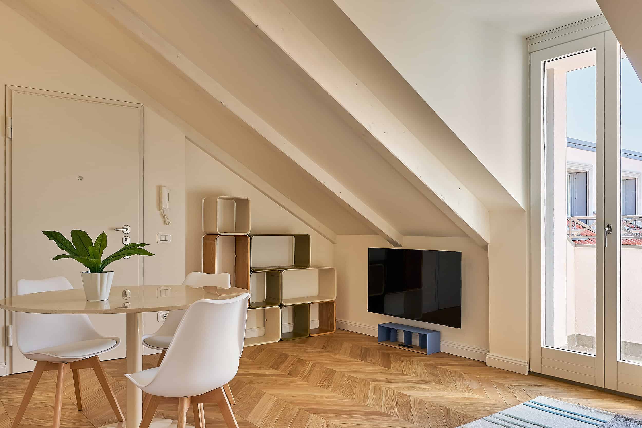 Contemporary attic living room with minimalist furniture and natural light.
