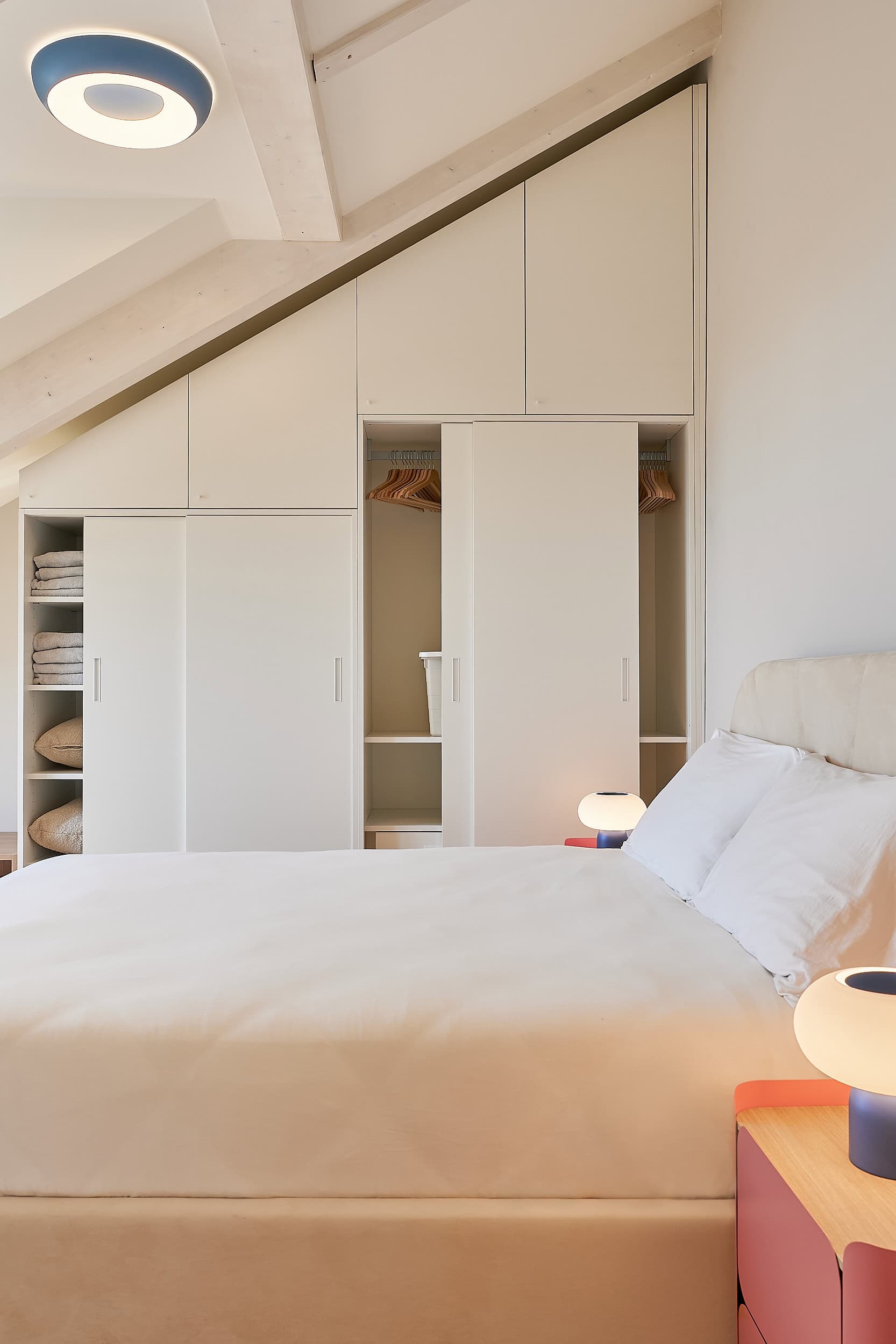 Contemporary bedroom with white built-in wardrobes and minimalist decor.