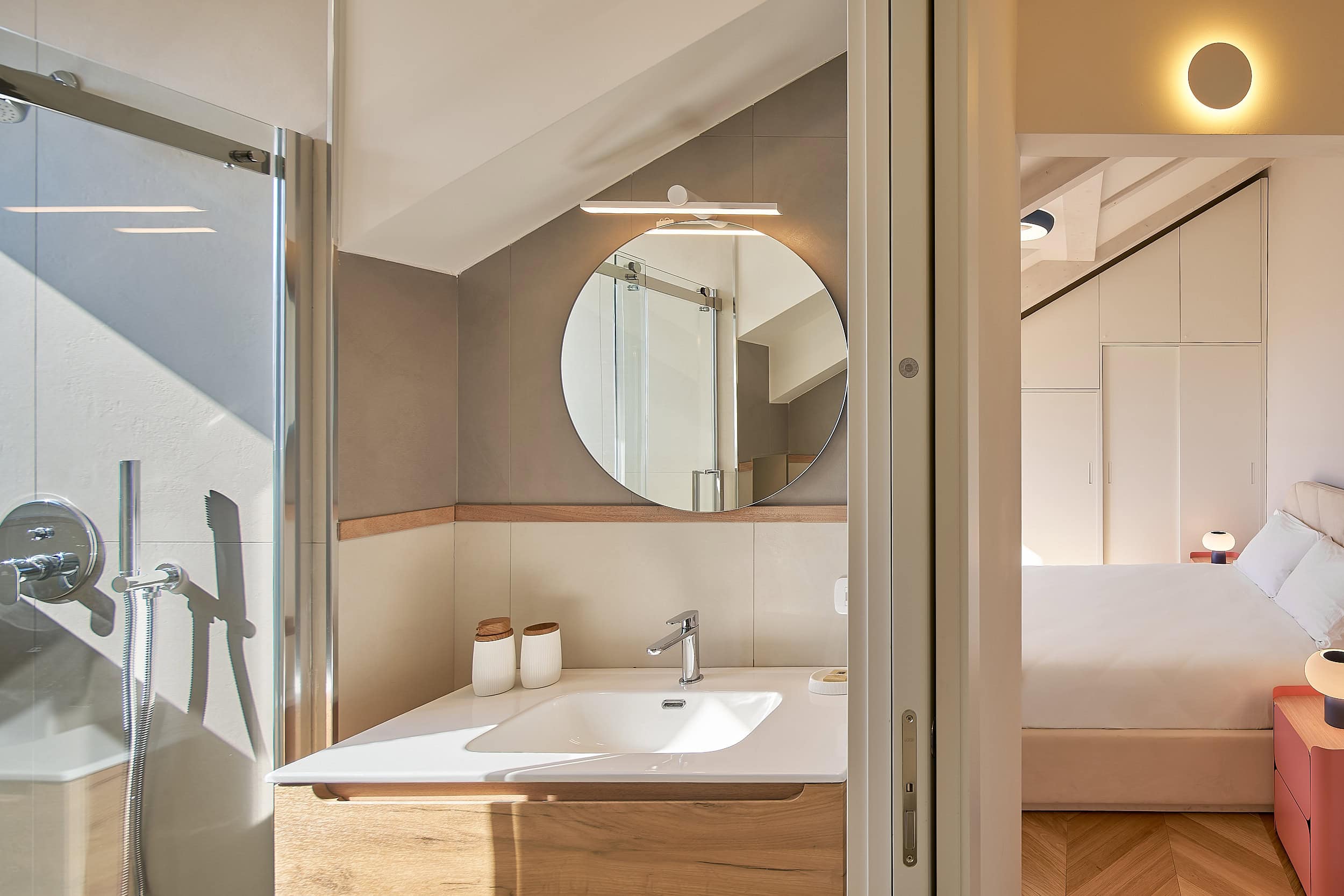 Contemporary bathroom with round mirror and minimalist decor.