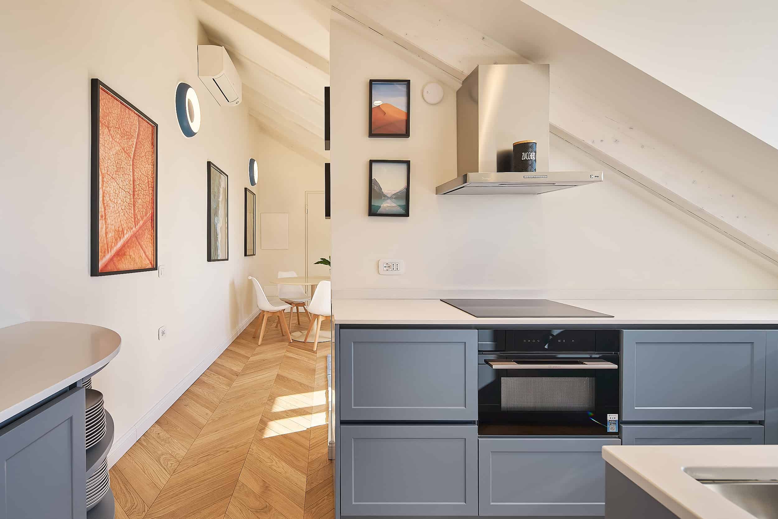 Contemporary kitchen with blue cabinets and artwork on the wall.