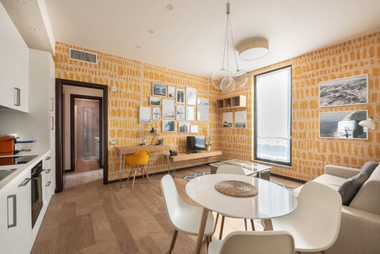 Modern Living Room With Yellow Brick Wall, Large Window, And Stylish Furniture.