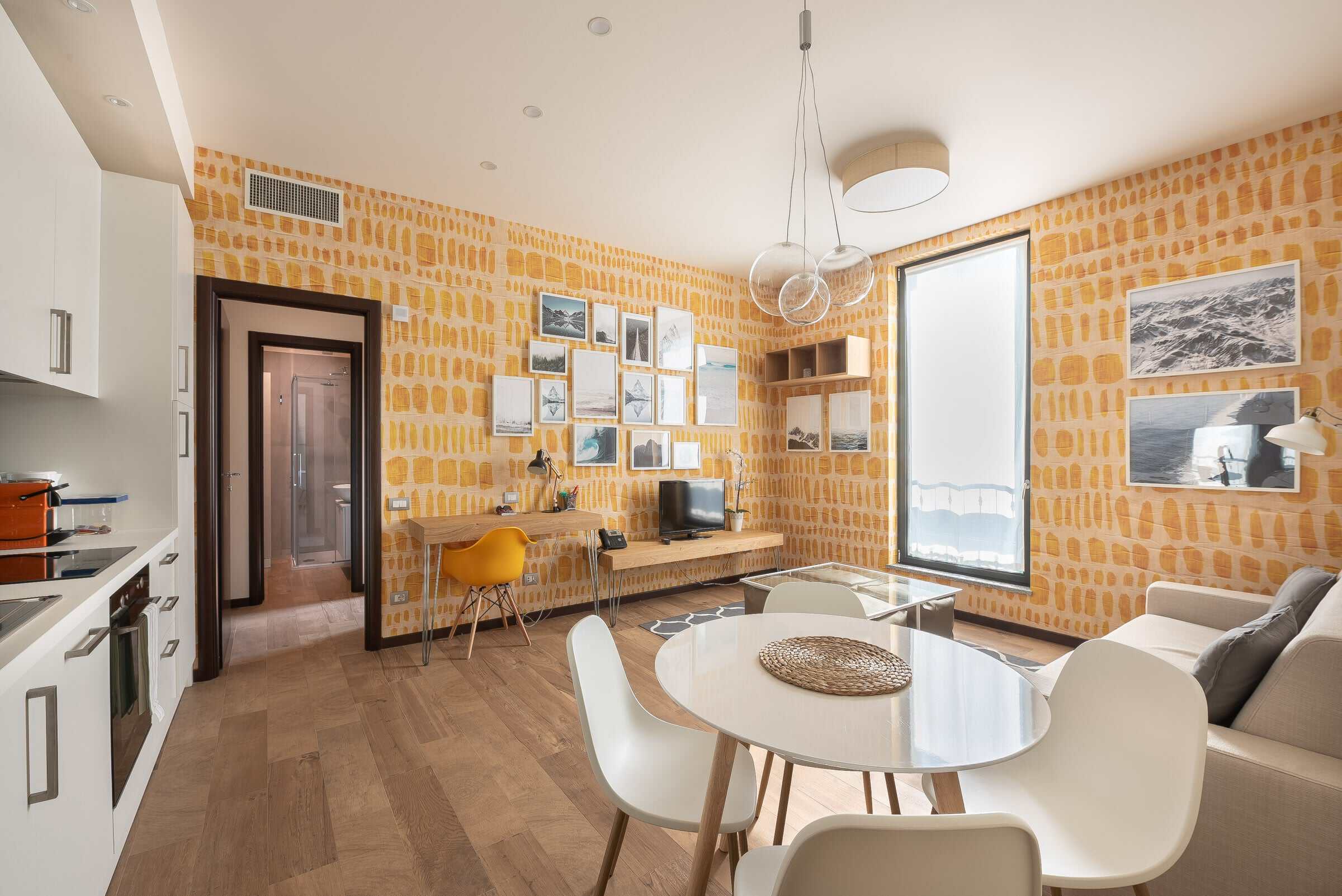 Modern living room with yellow brick wall, large window, and stylish furniture.