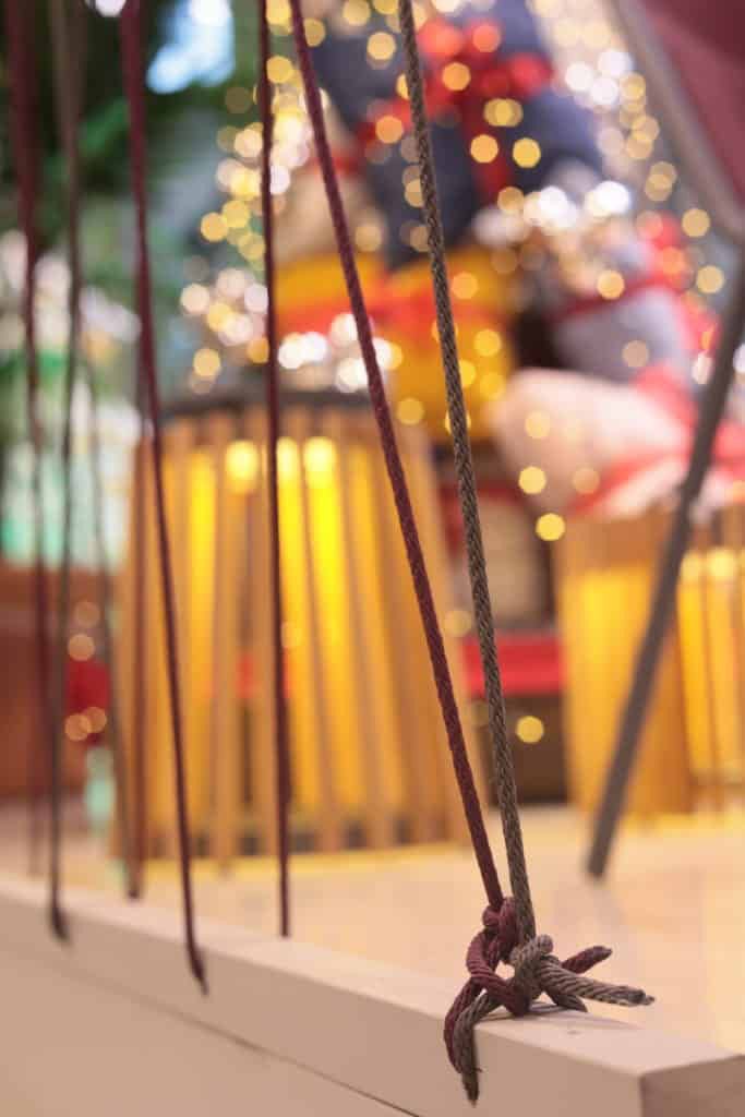 Close-Up Of A Swing With Blurred Festive Background And Lights.