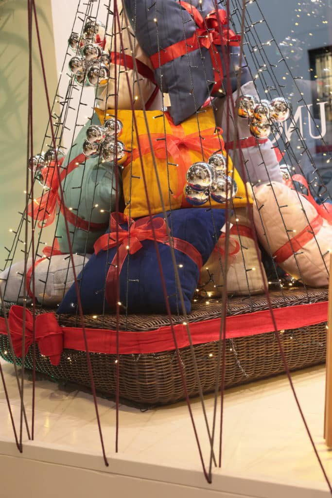 Colorful Wrapped Gifts With Ribbons And Ornaments In A Festive Display.