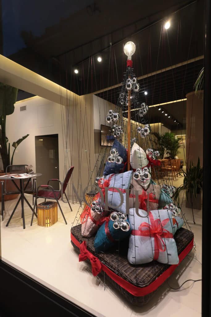 Festive Holiday Display With Wrapped Gifts And Ornaments At Architects Srl.