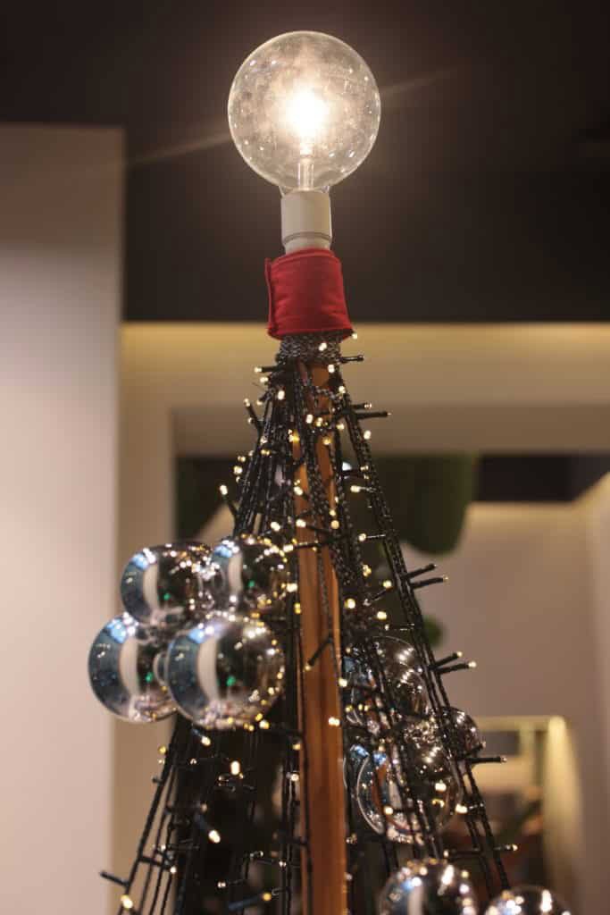 Unique Christmas Tree With Light Bulb Top And Metallic Ornaments.