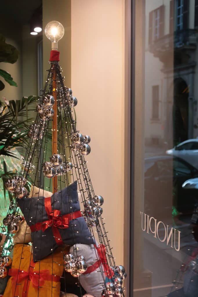 Festive Christmas Tree With Ornaments And Gifts In A Store Window.