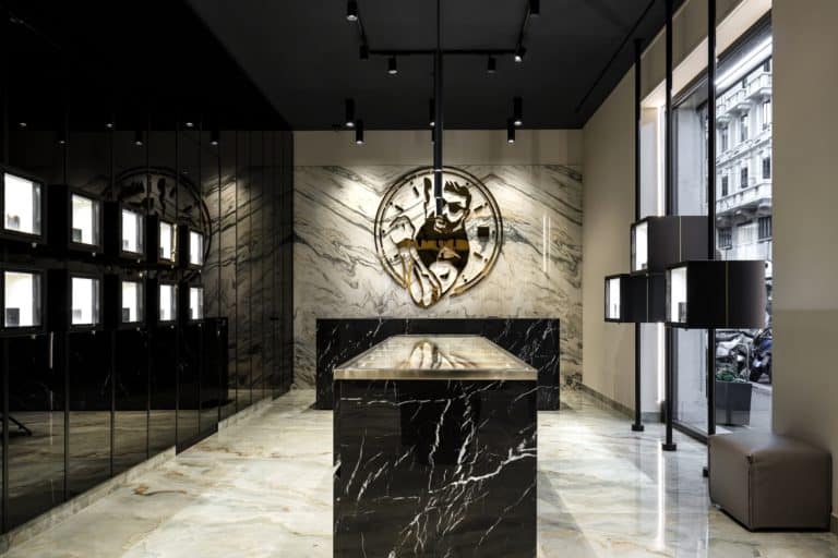 Elegant Store Interior With Marble Walls And A Central Display Table For Watches And Bags.