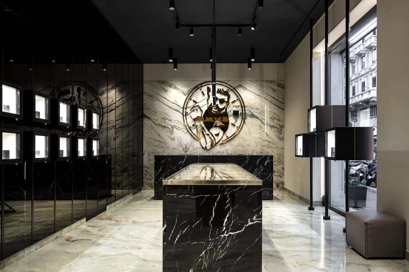Elegant store interior with marble walls and a central display table for watches and bags.