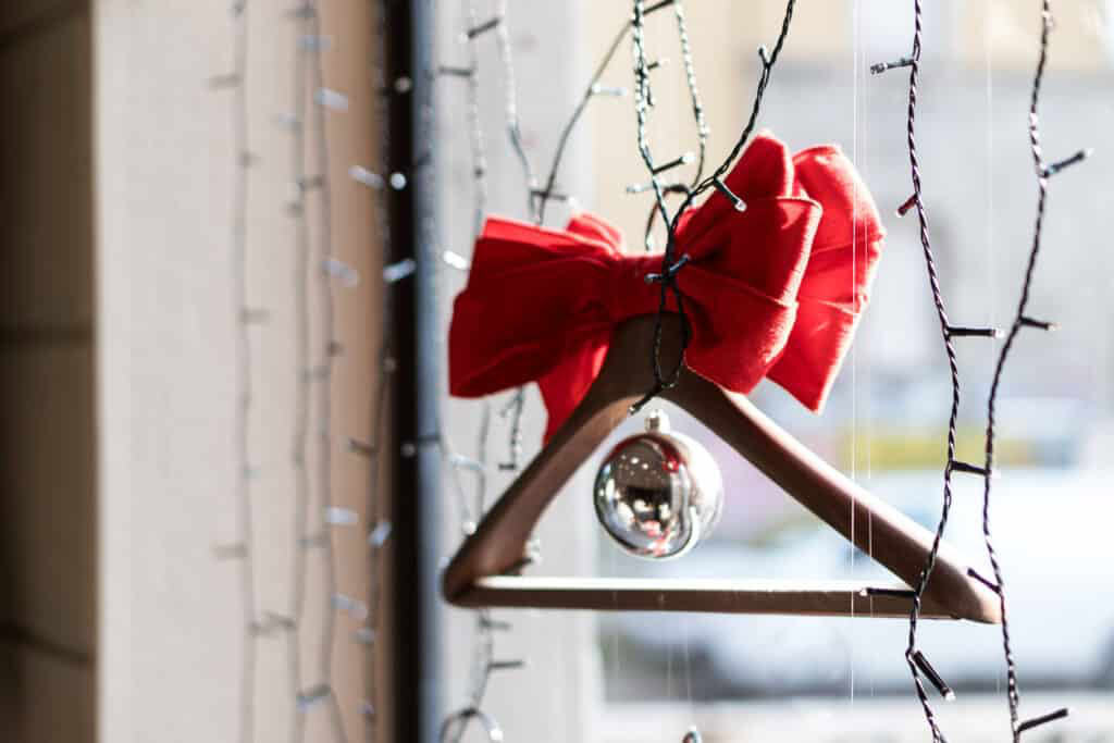 Decorative Christmas Ornament With Red Bow Hanging On A Window.