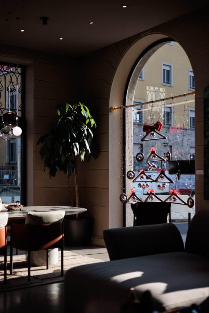 Interior Of A Modern Cafe With A Large Arched Window And Decorative Bicycle Sculpture.