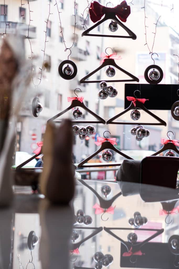 Decorative Christmas Ornaments Hanging On A Window With City View.