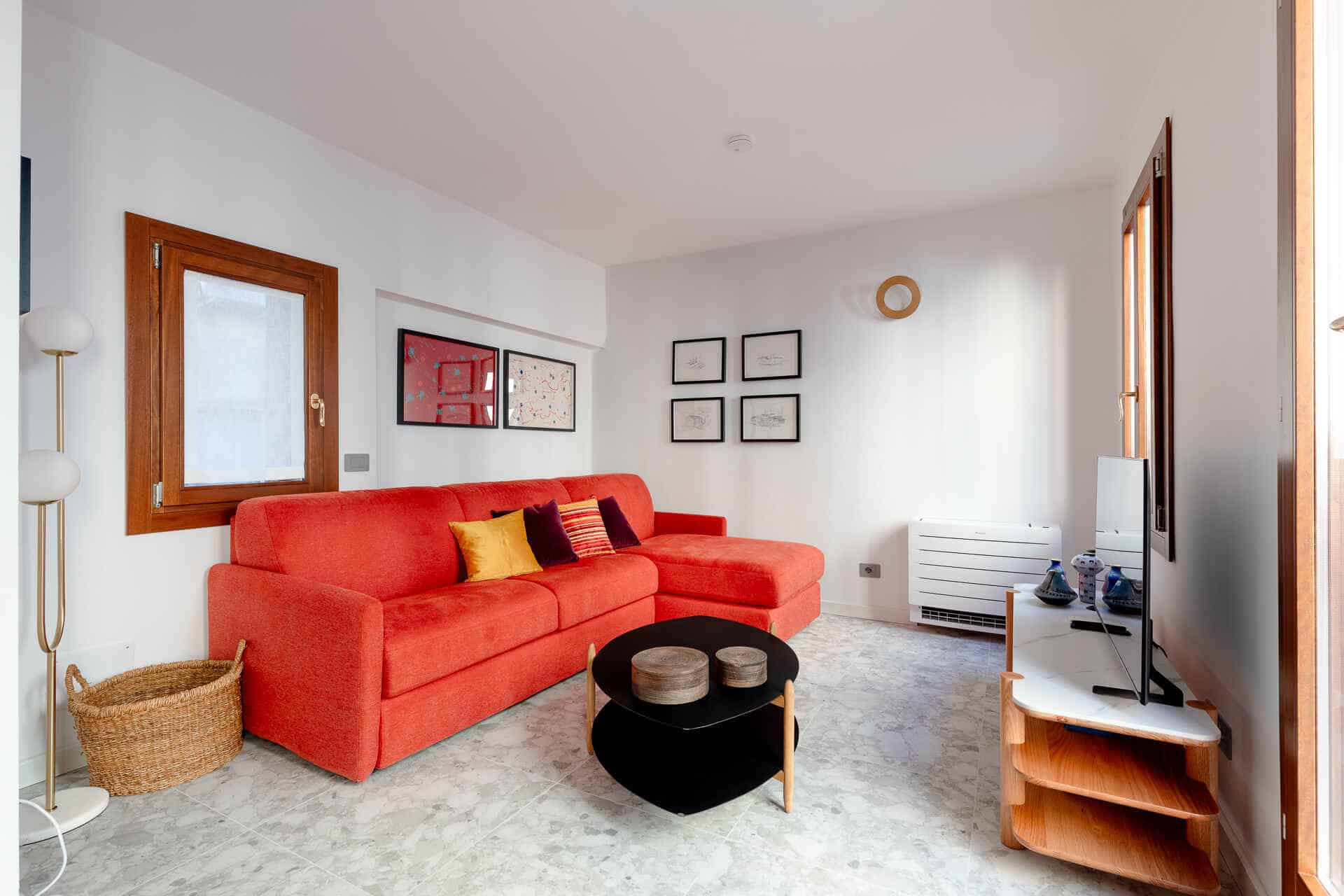 Modern living room with red sofa and minimalist decor.