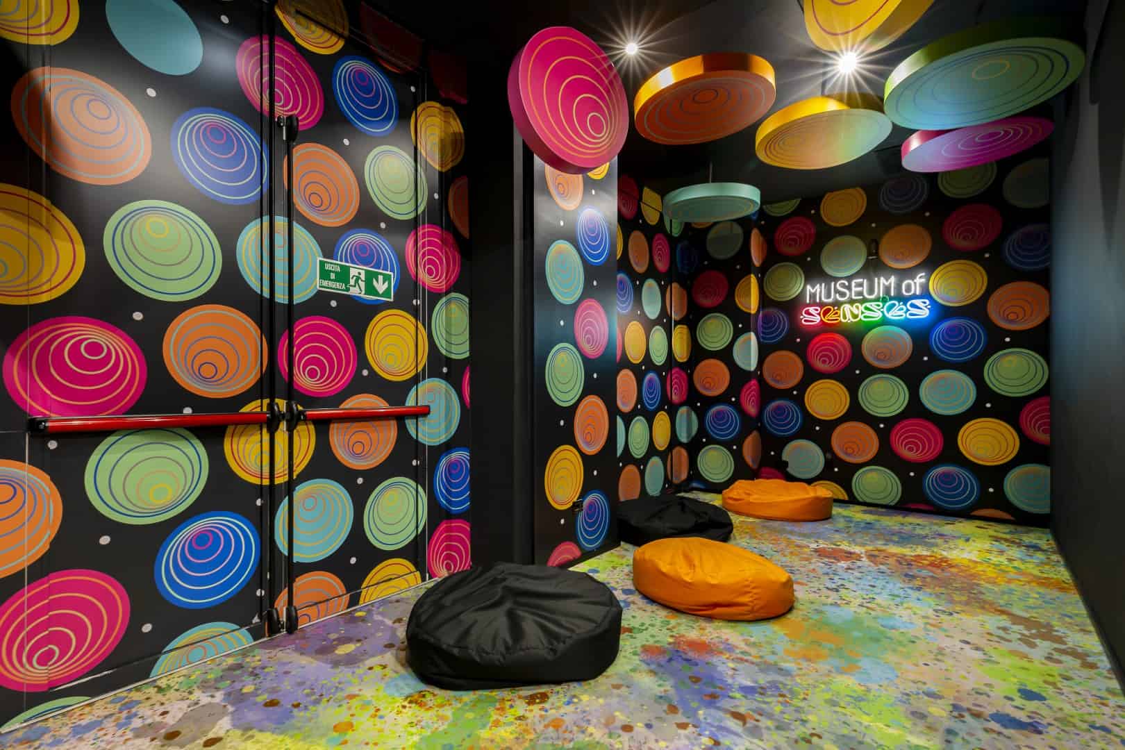 Colorful, psychedelic interior of the Museum of Senses with vibrant patterns and bean bags.