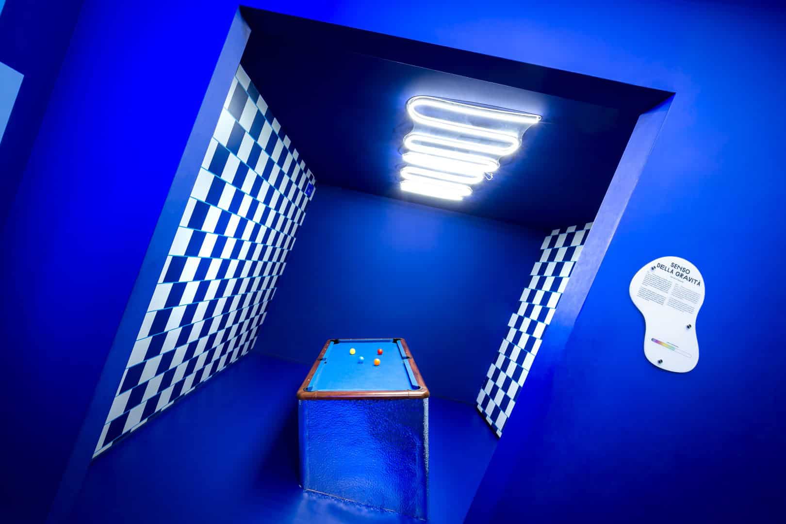 Blue-themed room with neon light and checkered walls at Museum of Senses.