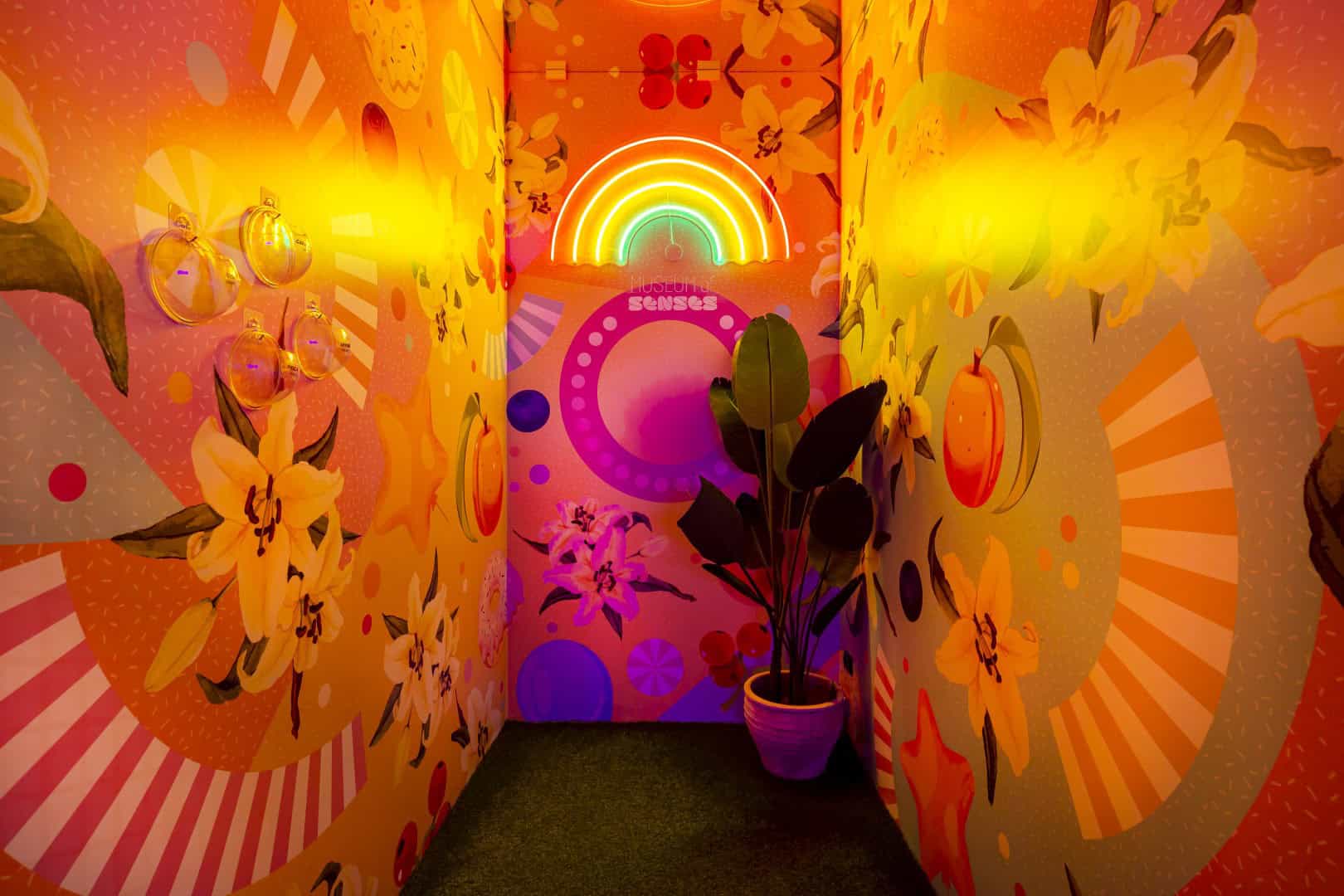 Colorful, vibrant hallway with floral and rainbow murals at Museum of Senses.