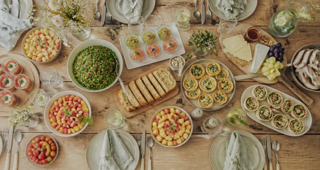 Repas froid entre amis sur grande table avec plats variés