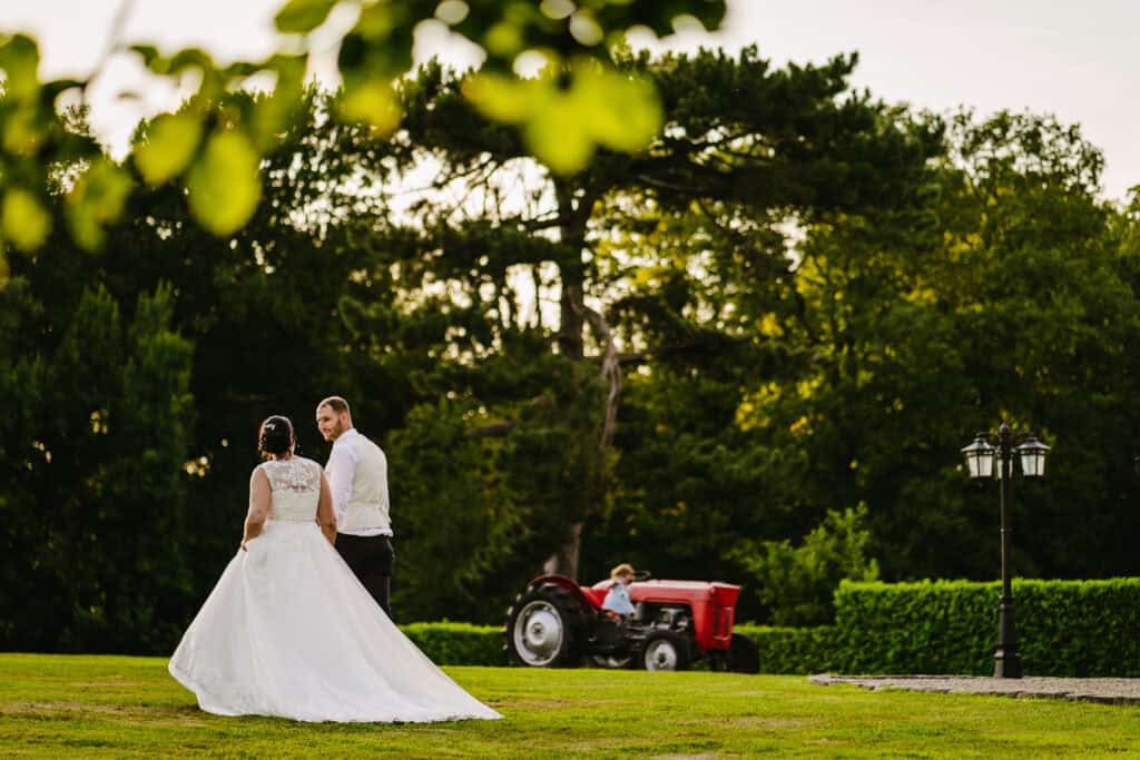 Wedding couple at Hyde Bank Farm with tractor in the background.