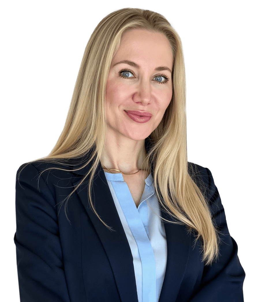 Portrait of a smiling businesswoman with long blonde hair in a navy blazer, in a bright office setting.