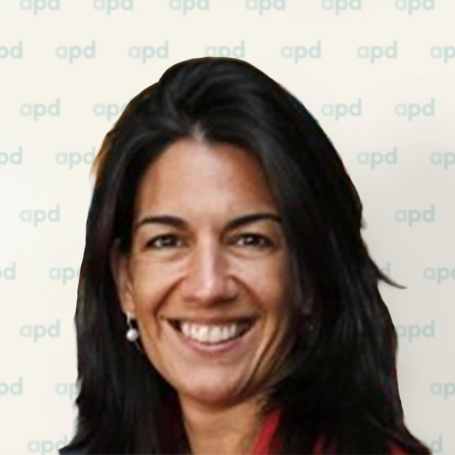 Smiling woman with dark hair in front of a light backdrop featuring a repeating 'apd' logo pattern.