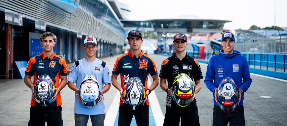Five young race drivers pose in a pit lane, each holding a helmet bearing Pont Group logos in front of team garages.