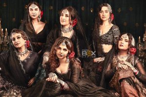 Elegant Women Dressed In Traditional Black Ethnic Attire With Jewelry, Posing In A Glamorous Setting For Inside Box Office.