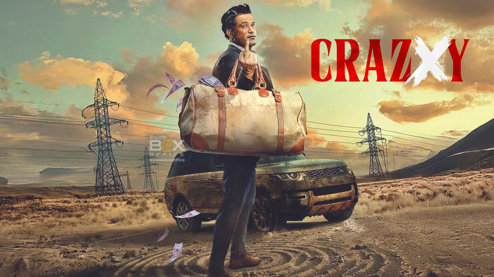 Luggage man standing in front of a dirt road with a luxury car and power lines under a colorful sky, promoting the film "Crazy Xy" with bold red text.