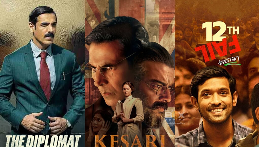 A man in a teal checkered suit with a red tie, portraying a serious character, standing outdoors with a neutral background.