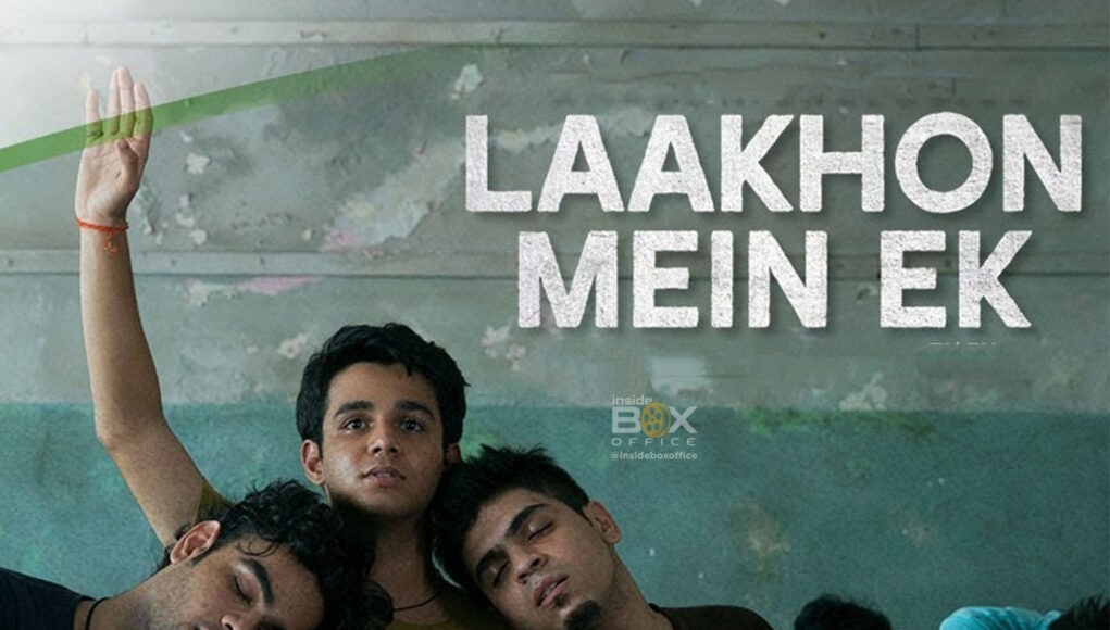 A tired young man resting his head on his friends' shoulders during a movie scene, with the text "Laakhon Mein Ek" overlayed. The image represents the movie "Laakhon Mein Ek" available on Inside Box Office, highlighting youth and friendship.