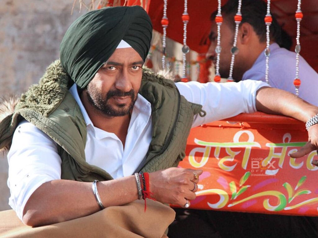 A Man Wearing A Black Turban And A White Shirt With A Green Vest Rides In A Vibrant Decorated Vehicle, Capturing A Lively Cultural Scene.