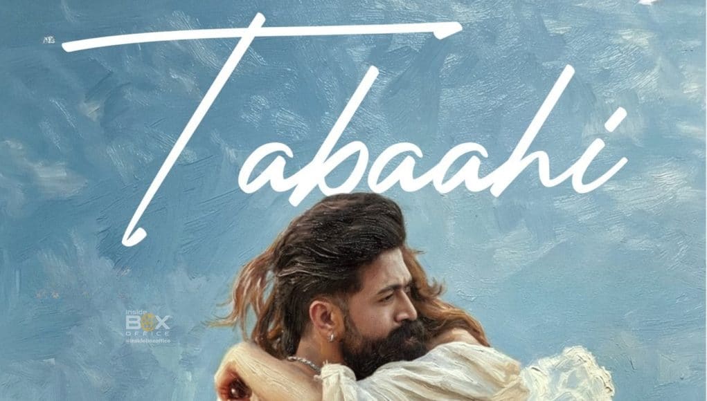 An intense scene from the Indian action thriller film "Tabahi" featuring a man and woman embracing each other against a cloudy sky background.