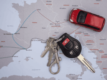 Chiavi di auto e modellino su mappa Europa, nozioni di noleggio veicoli.